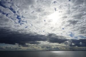 Sunlight breaking through beautiful clouds over calm water