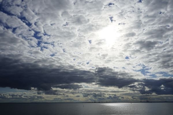 Sunlight breaking through beautiful clouds over calm water